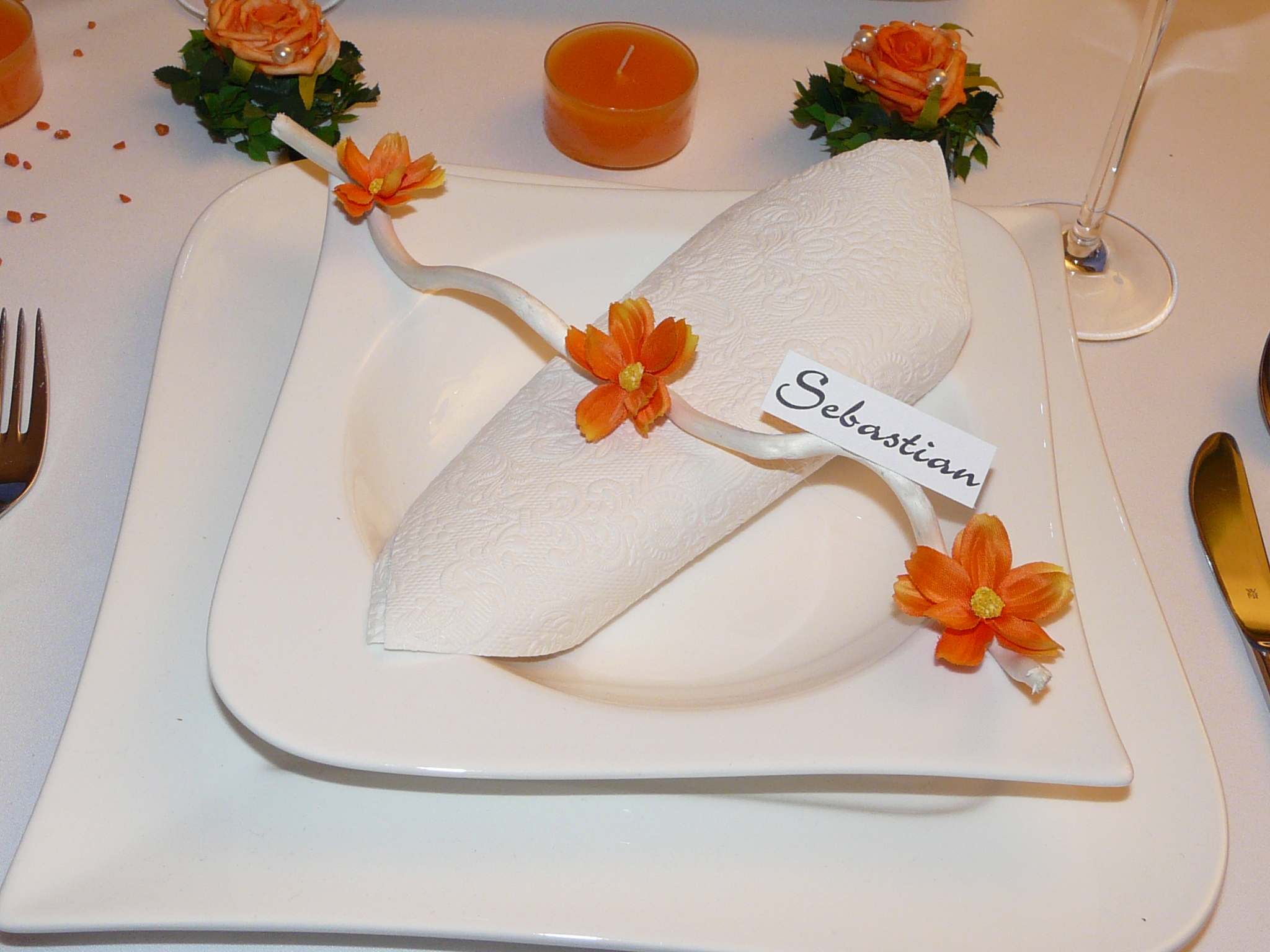 Detailaufnahme Tischdeko Hochzeit - ein Mustertisch in Orange mit einer Rose in Rosenblättern. Streudeko orange, Kuwa und Tischdekoration der besonderen Art.